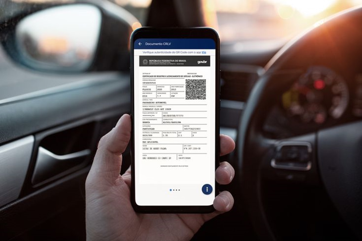 Documento CRLV digital exibido na tela de um celular dentro de um veículo.