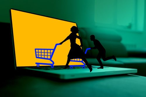 Representação conceitual de compras online com silhuetas empurrando carrinhos de compras saindo de uma tela de notebook, simbolizando a experiência de anunciar no Instagram Shopping.