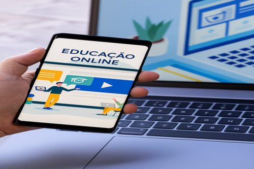 Tela de smartphone com interface de educação digital e laptop ao fundo em ambiente de trabalho